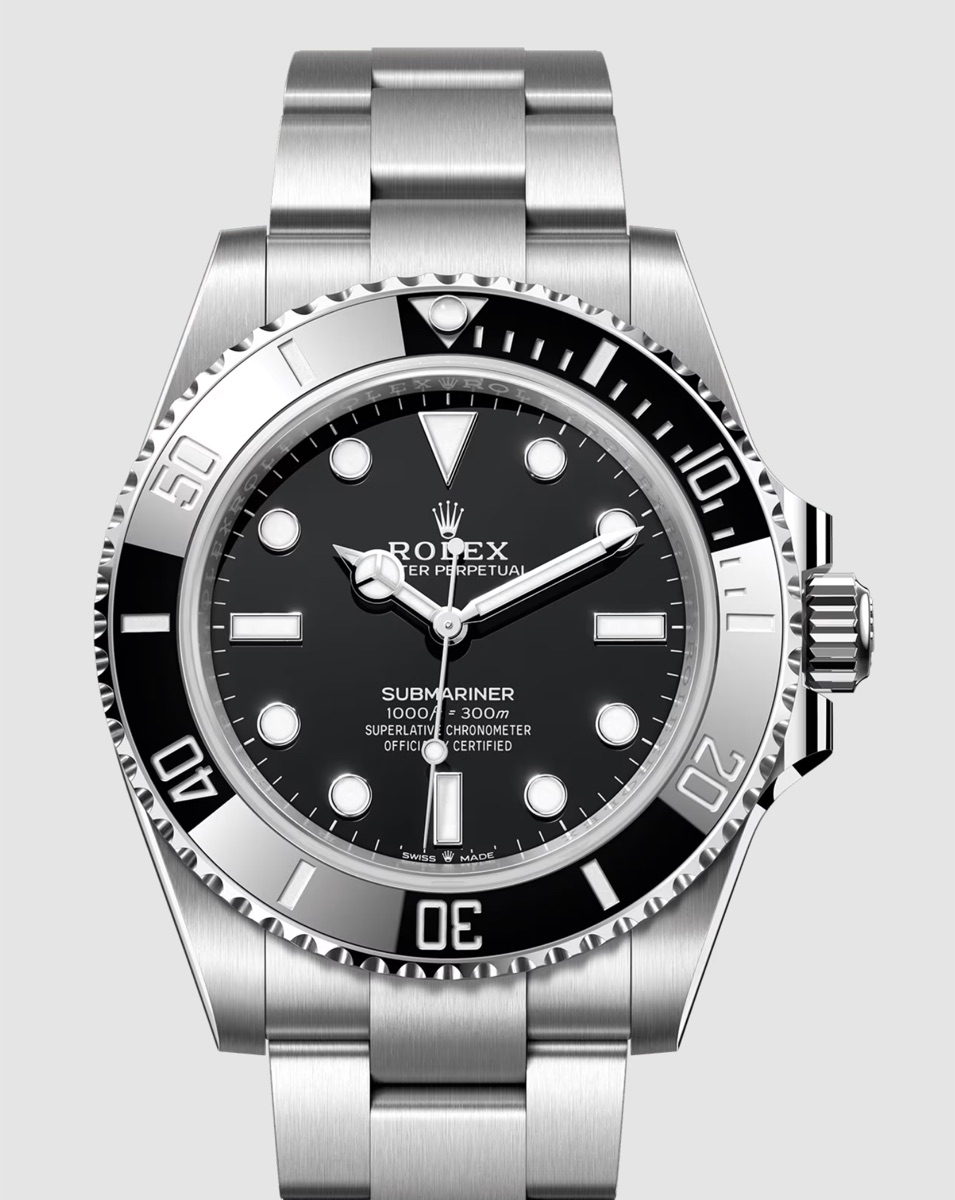 Close-up of a black dive watch with a black rotating bezel: a luminous pip in a triangle at zero, and individual minute markings through the first quarter of the ring